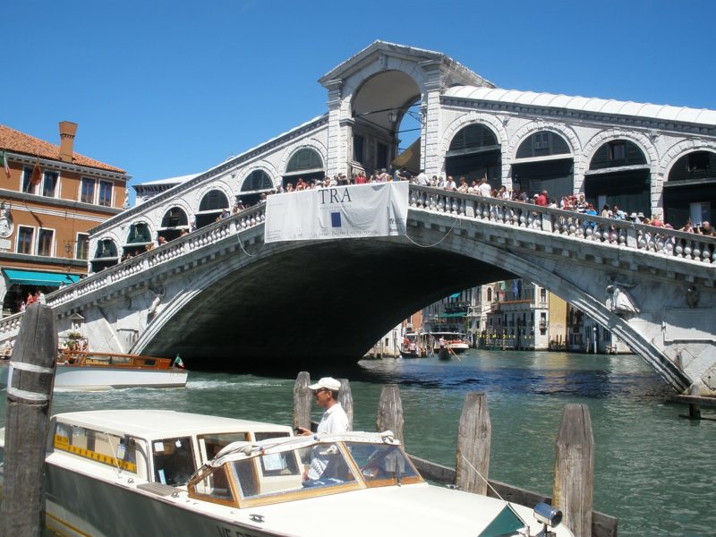 Многочисленные туристы на мосту Риальто в Венеции